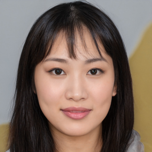 Joyful asian young-adult female with long  brown hair and brown eyes