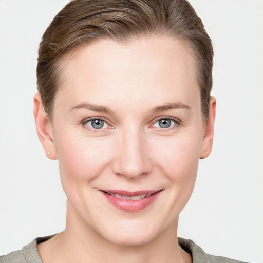 Joyful white young-adult female with short  brown hair and blue eyes