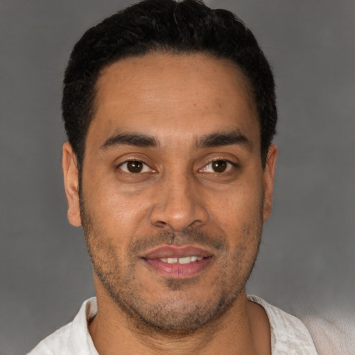 Joyful latino young-adult male with short  black hair and brown eyes