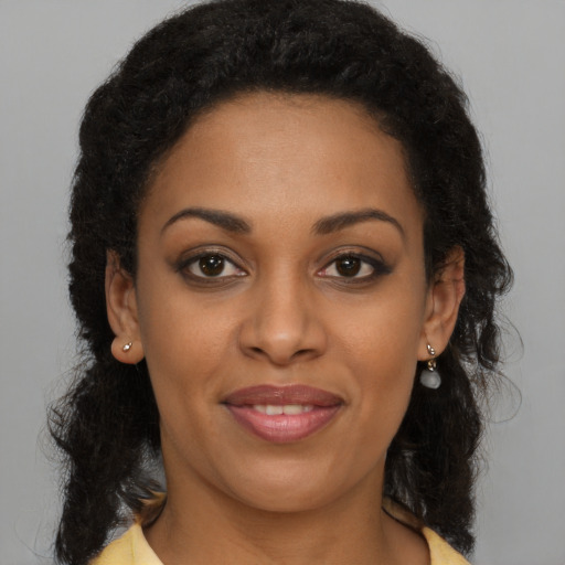 Joyful black young-adult female with long  brown hair and brown eyes