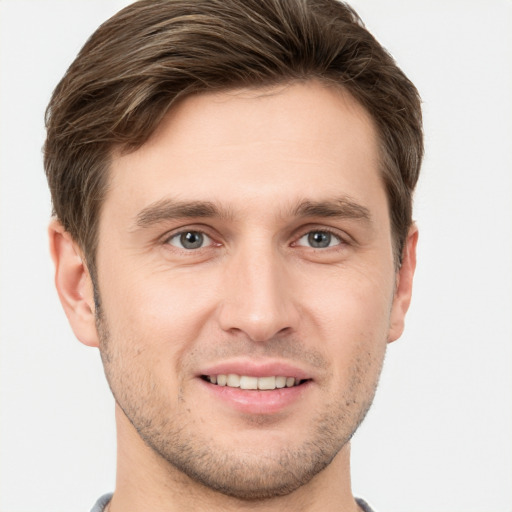 Joyful white young-adult male with short  brown hair and grey eyes