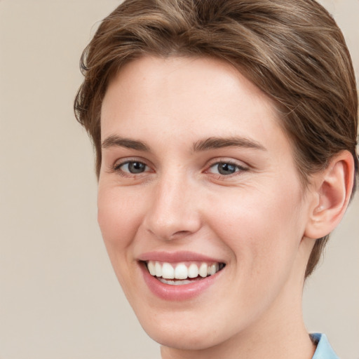 Joyful white young-adult female with short  brown hair and grey eyes