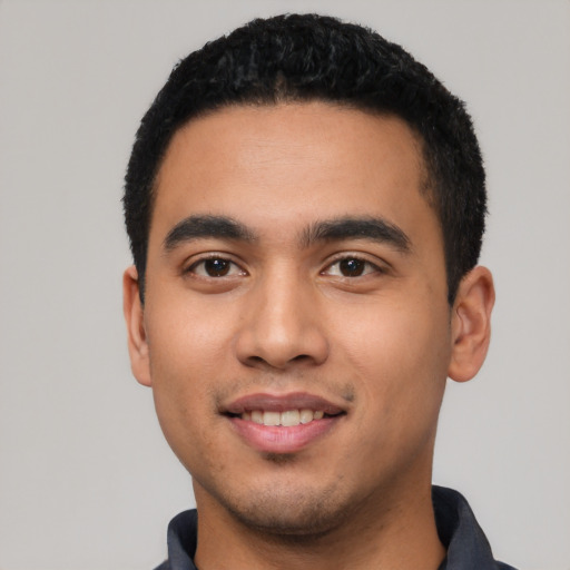 Joyful latino young-adult male with short  black hair and brown eyes