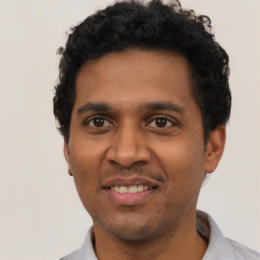 Joyful black young-adult male with short  black hair and brown eyes