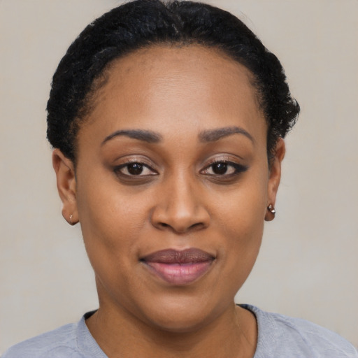 Joyful black young-adult female with short  black hair and brown eyes
