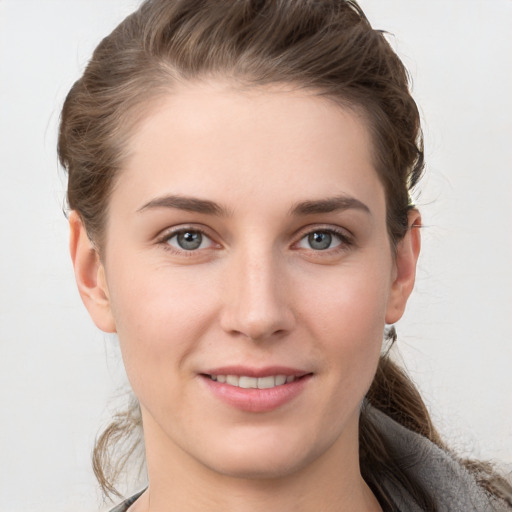 Joyful white young-adult female with medium  brown hair and grey eyes