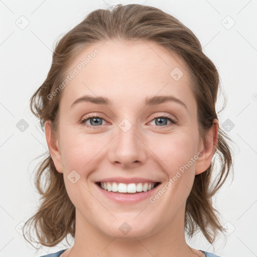 Joyful white young-adult female with medium  brown hair and blue eyes