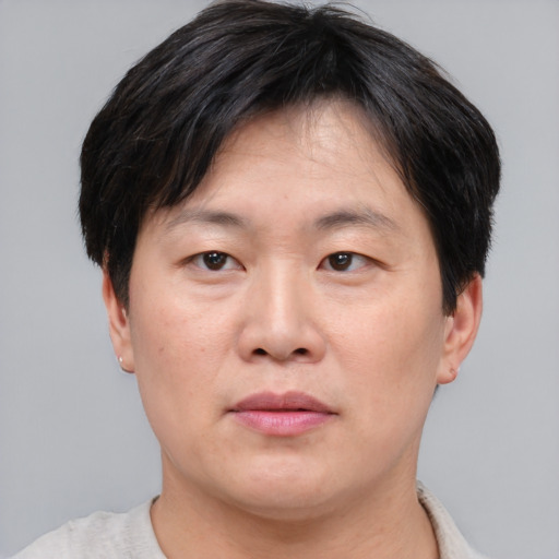 Joyful asian adult male with short  brown hair and brown eyes