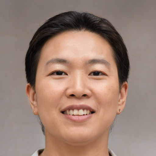 Joyful asian young-adult female with short  brown hair and brown eyes