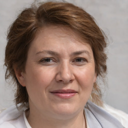 Joyful white adult female with medium  brown hair and blue eyes