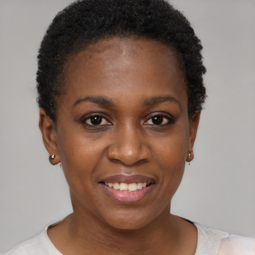 Joyful black young-adult female with short  black hair and brown eyes