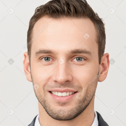 Joyful white young-adult male with short  brown hair and grey eyes