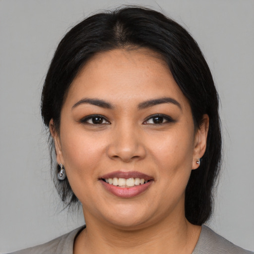 Joyful latino young-adult female with medium  black hair and brown eyes