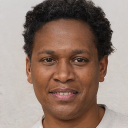 Joyful black adult male with short  brown hair and brown eyes
