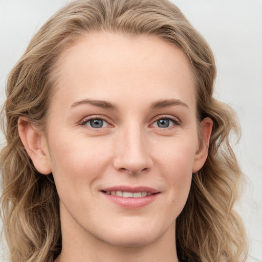 Joyful white young-adult female with long  brown hair and blue eyes