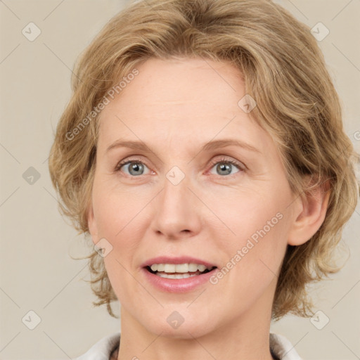 Joyful white adult female with medium  brown hair and blue eyes