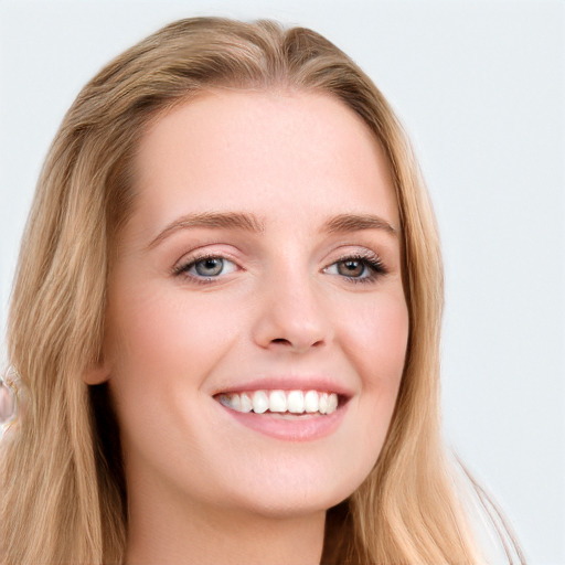 Joyful white young-adult female with long  brown hair and blue eyes