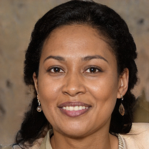 Joyful black adult female with medium  brown hair and brown eyes