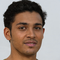 Joyful latino young-adult male with short  brown hair and brown eyes