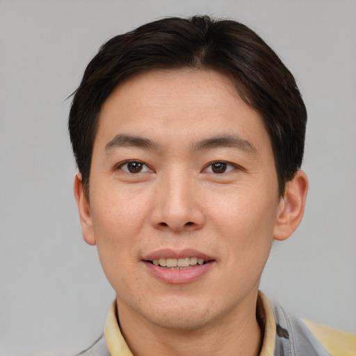 Joyful asian young-adult male with short  brown hair and brown eyes