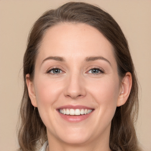 Joyful white young-adult female with long  brown hair and grey eyes