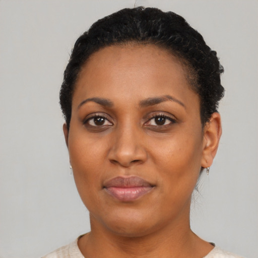Joyful black adult female with short  black hair and brown eyes