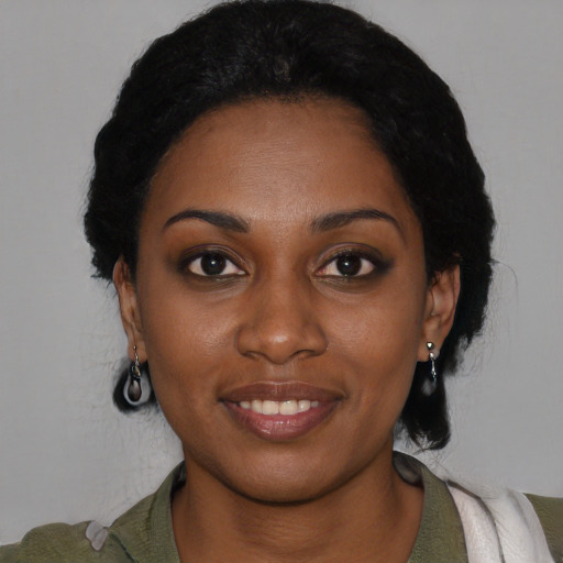 Joyful black young-adult female with medium  black hair and brown eyes
