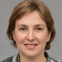 Joyful white adult female with medium  brown hair and grey eyes