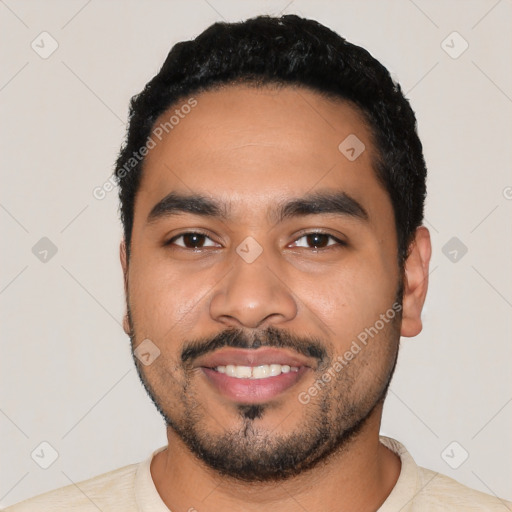 Joyful latino young-adult male with short  black hair and brown eyes