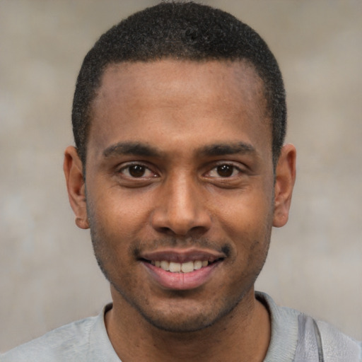 Joyful black young-adult male with short  black hair and brown eyes