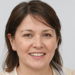 Joyful white adult female with medium  brown hair and brown eyes