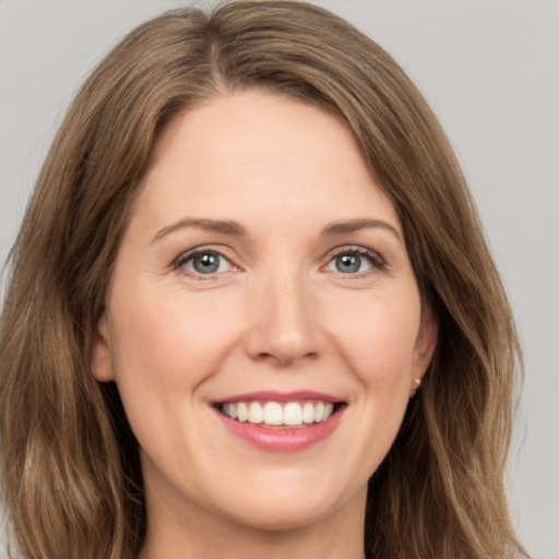 Joyful white young-adult female with long  brown hair and green eyes