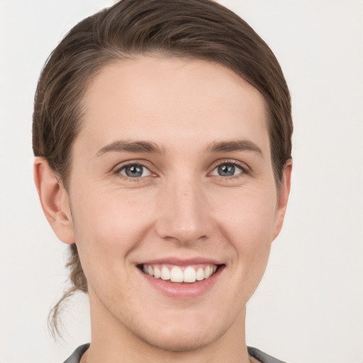 Joyful white young-adult female with short  brown hair and grey eyes