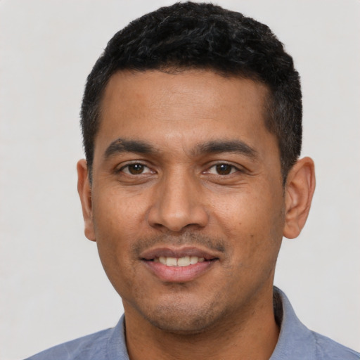 Joyful latino young-adult male with short  black hair and brown eyes