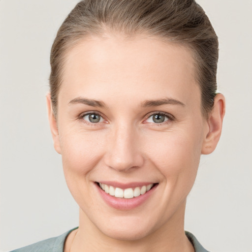 Joyful white young-adult female with short  brown hair and grey eyes