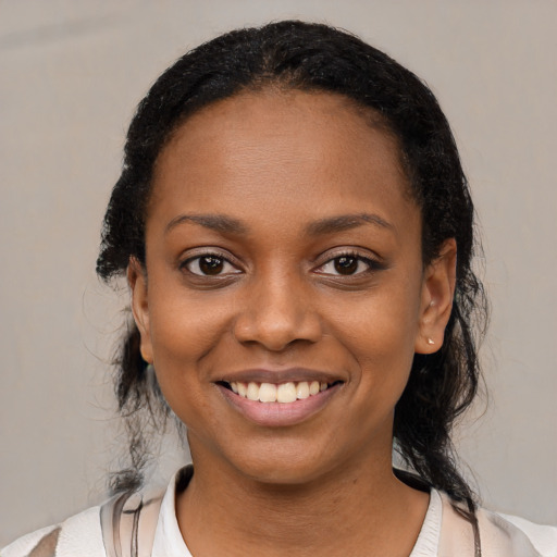 Joyful black young-adult female with medium  black hair and brown eyes