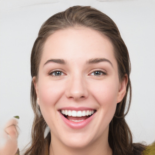 Joyful white young-adult female with long  brown hair and grey eyes