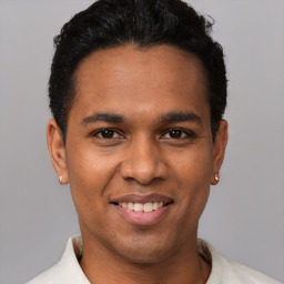 Joyful latino young-adult male with short  brown hair and brown eyes