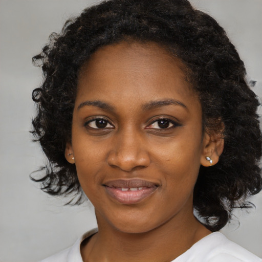 Joyful black young-adult female with medium  black hair and brown eyes