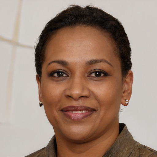 Joyful black adult female with short  black hair and brown eyes
