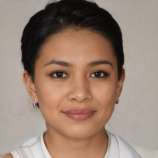 Joyful latino young-adult female with short  black hair and brown eyes