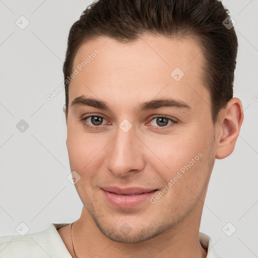 Joyful white young-adult male with short  brown hair and brown eyes