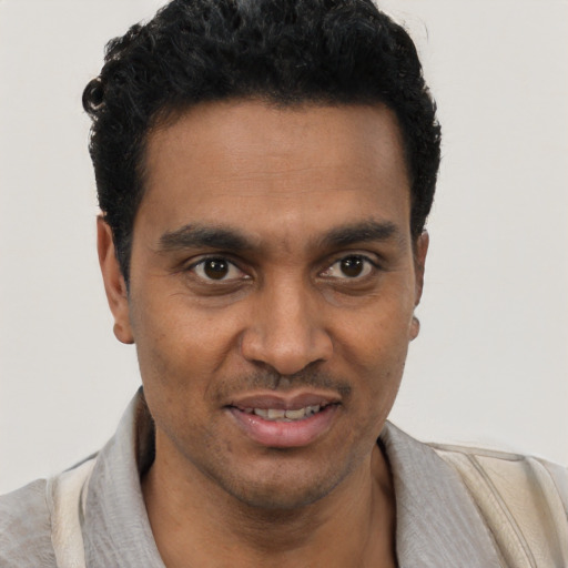 Joyful black young-adult male with short  black hair and brown eyes