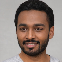 Joyful black young-adult male with short  black hair and brown eyes