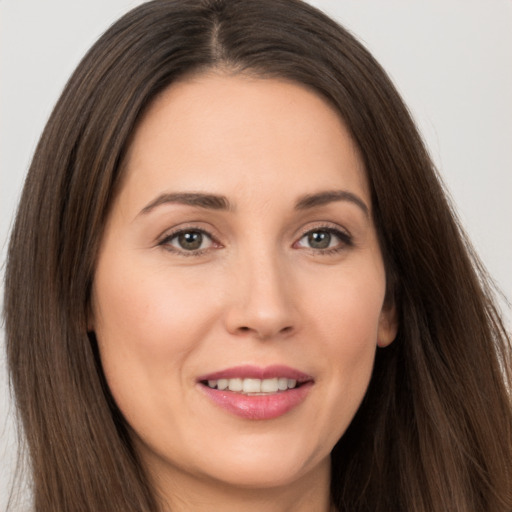 Joyful white young-adult female with long  brown hair and brown eyes