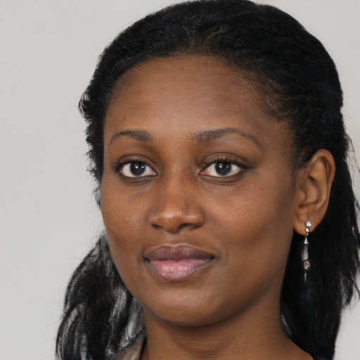 Joyful black young-adult female with long  black hair and brown eyes