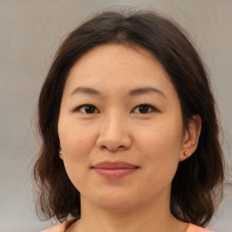 Joyful asian young-adult female with medium  brown hair and brown eyes