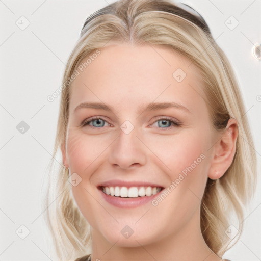 Joyful white young-adult female with long  brown hair and blue eyes