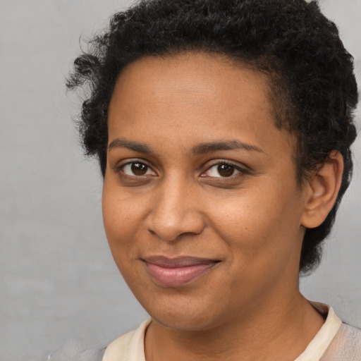 Joyful black young-adult female with short  brown hair and brown eyes