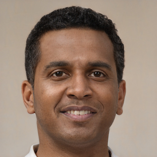 Joyful black young-adult male with short  brown hair and brown eyes